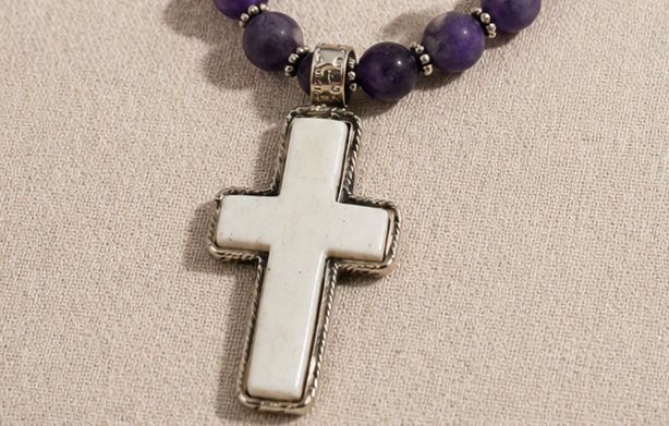 Hand-carved bone cross pendant detail on artisan necklace