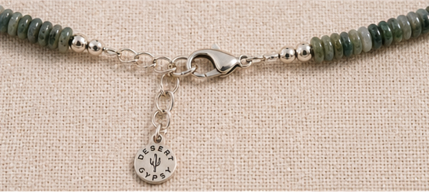 Hand-carved bone flower pendant detail on artisan necklace