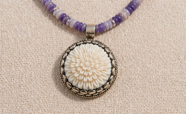 Hand-carved bone flower pendant detail on artisan necklace
