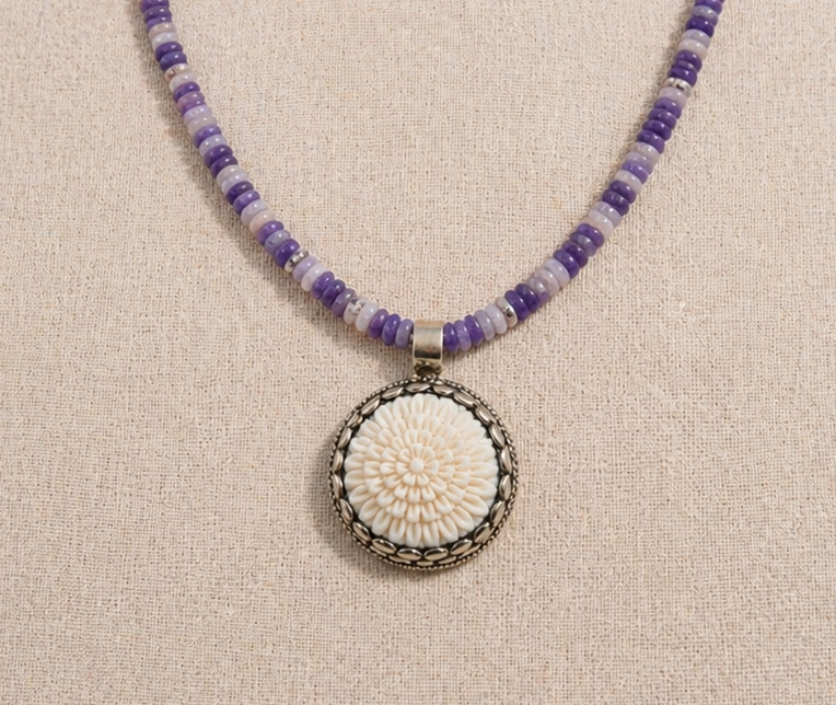 High Desert Amethyst Necklace with purple amethyst beads and carved bone flower pendant on linen background