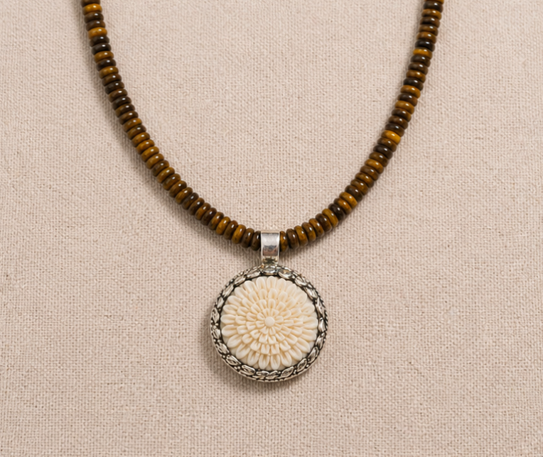 High Desert Tiger’s Eye Necklace with brown and gold tiger’s eye beads and carved bone flower pendant on linen background